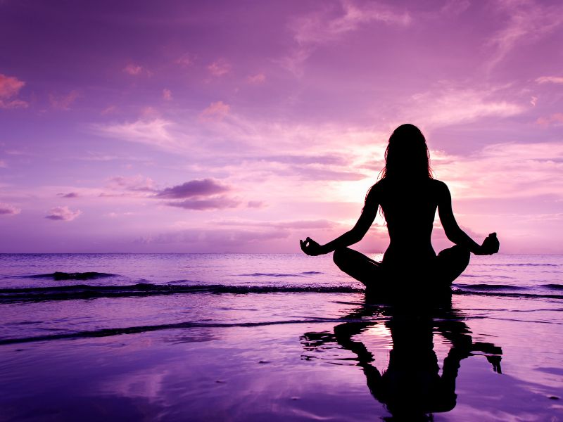 Person meditating with a glowing third eye symbol